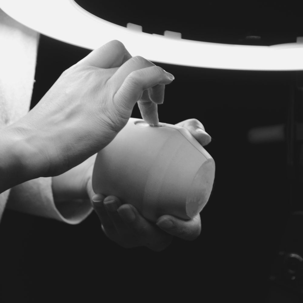 Nikki, our founder, inspecting the finish of a production case Luna jar. Black and white image.