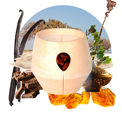 Image of Luna Amber Oro candle with its scent collage at the back - the text reads: Discover the fusion of Myrrh and Frankincense with Tigers Eye in our 24k gold-speckled vessel. This scent creates a rich, inviting aroma for a positive, confidence-boosting, well-balanced space.